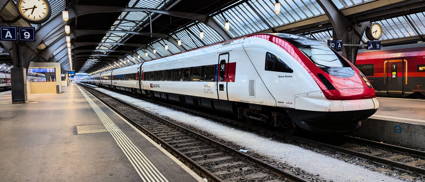 Czerwono– biały pociąg na zadaszonym dworcu.
